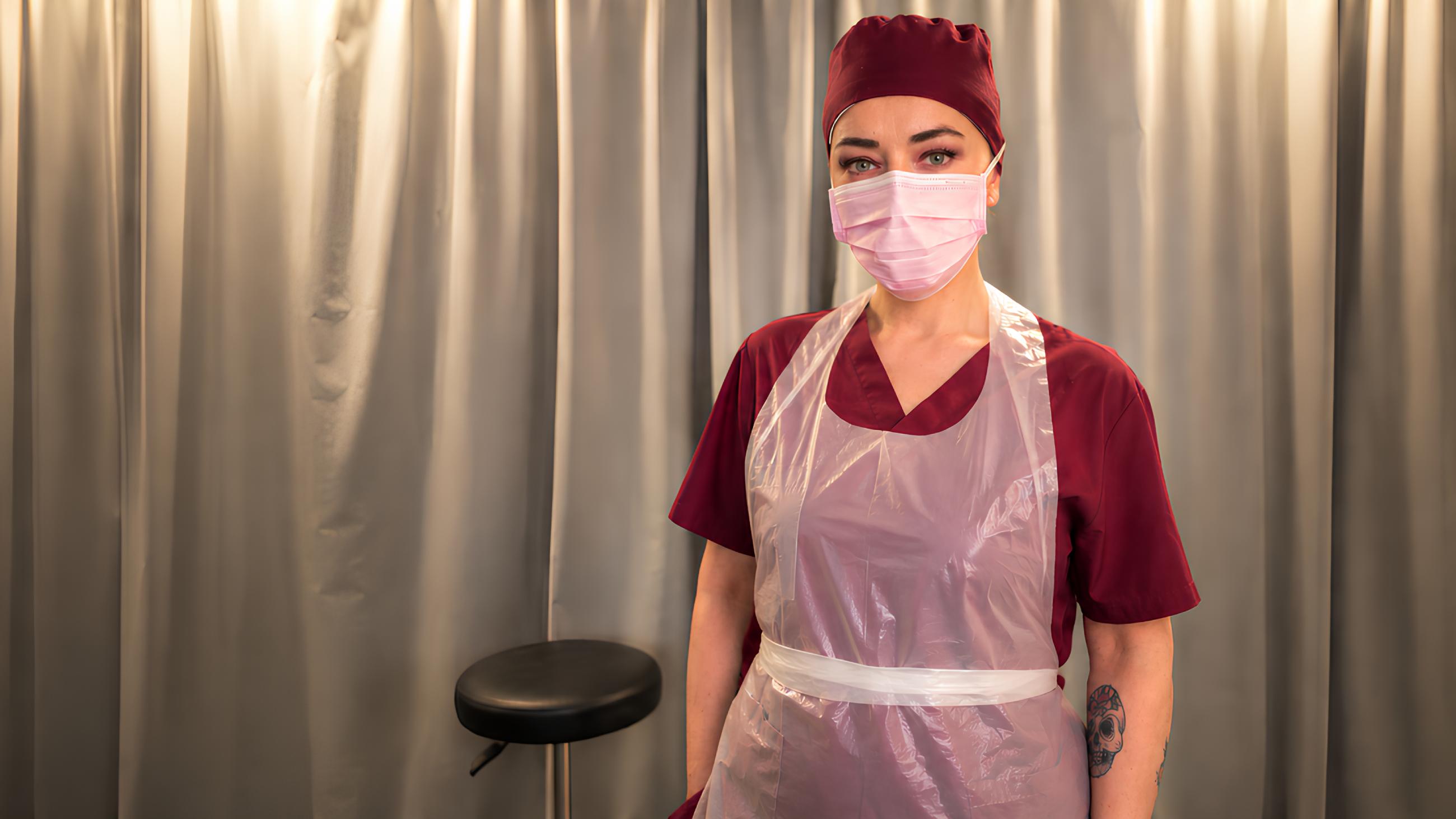 Miss Nena medical assistant wearing a PVC apron in Belgium during a session